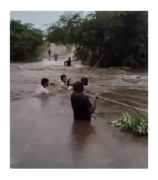 Moradores Atravessam Trecho Inundado Por Enchente Usando Corda Em Forquilha