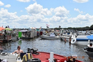 Chaos As Huge Party Flotilla Takes Over Sandbar As Tens Of Thousands Descend On Popular Florida Lake For Massive Drinking Marathon With Glamorous Woman Watching Drunk Men Brawl In The Water