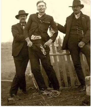 Photo: Outlaw John Shaw Removed From His Coffin And Propped Up Against A Picket Fence For One Last Drink Of Whiskey...